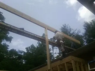 Carpenter setting a ridge beam over a new addition frame — Ice Dam Removal by Roofing Brothers in Middlebrook