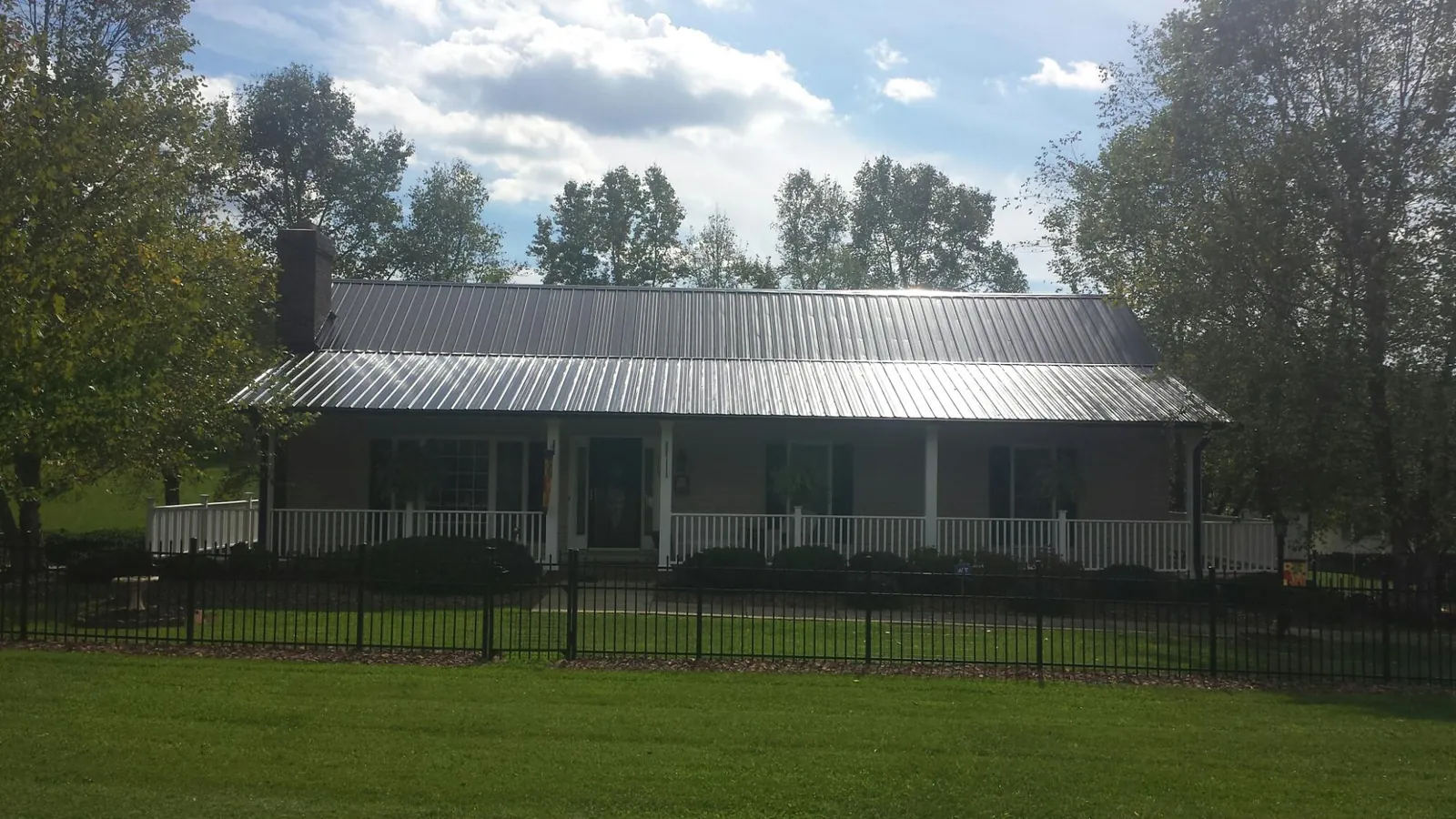Gray metal roof on a brick ranch with a full width front porch — Gutter Guard Installation work by our crew in Middlebrook