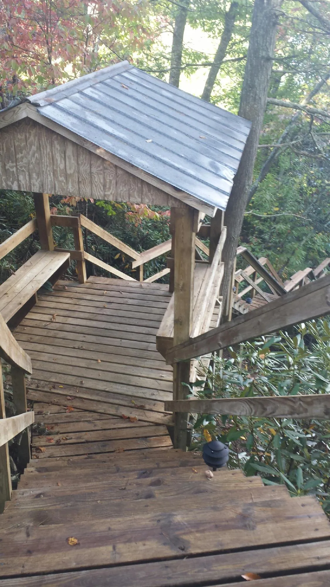 Metal roofed shelter over wooden steps on a wooded walkway — Skylight Repair & Installation work by our crew in Middlebrook
